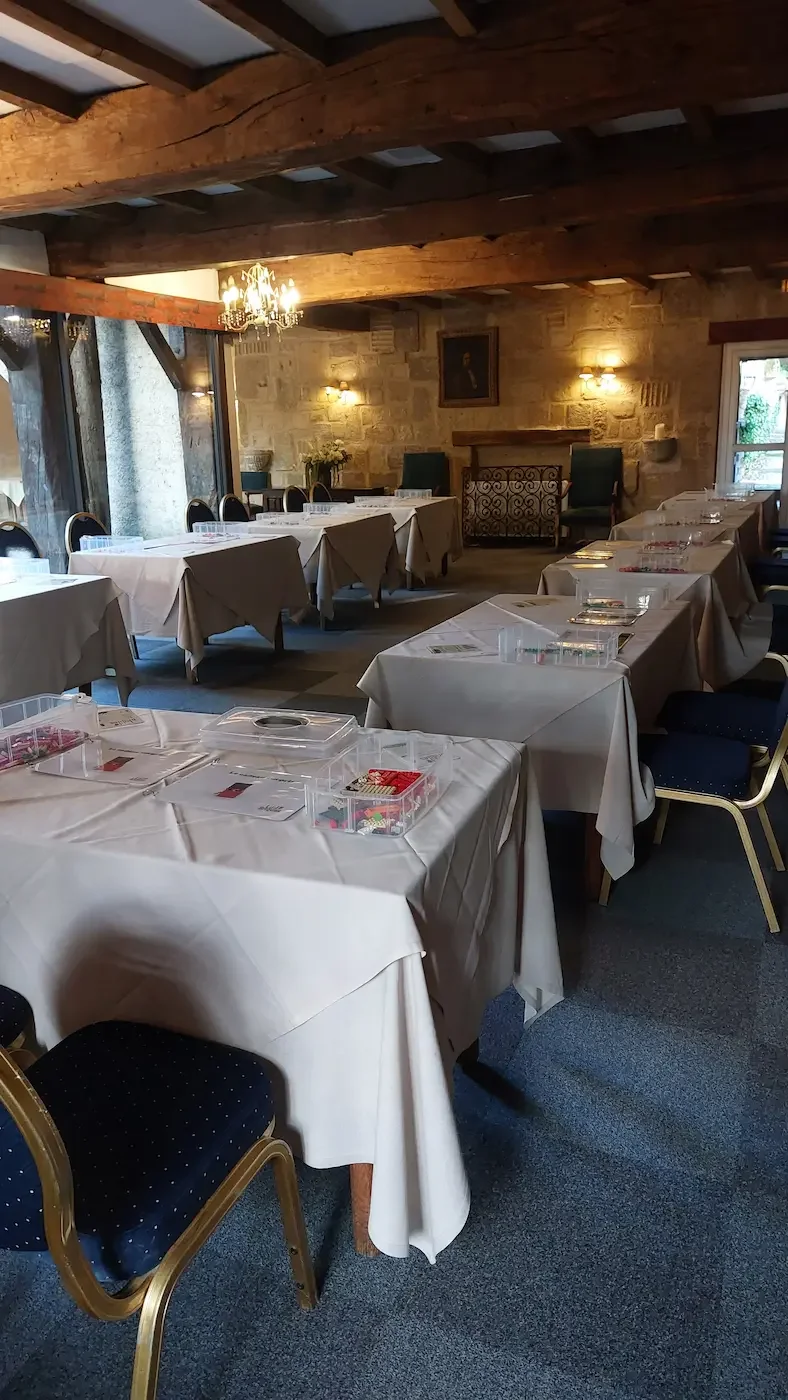 Séminaires 3 20/10/2026 Salle de réception installée pour une activité séminaire : tables nappées et bacs de briques LEGO® prêts pour les participants