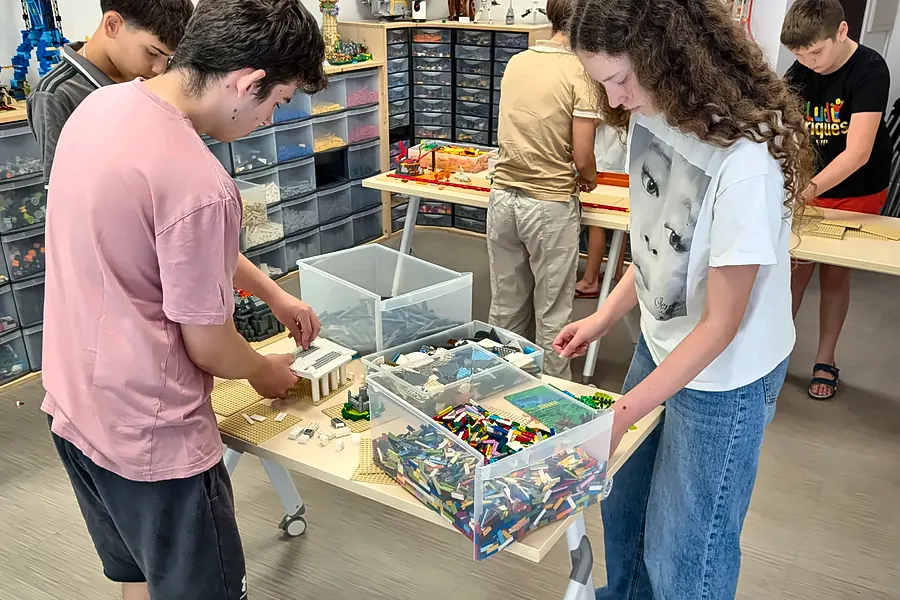 Deux adolescents trient des briques LEGO® dans un grand bac transparent, pendant une séance d'accès libre dans la salle de jeux de Salon-de-Provence