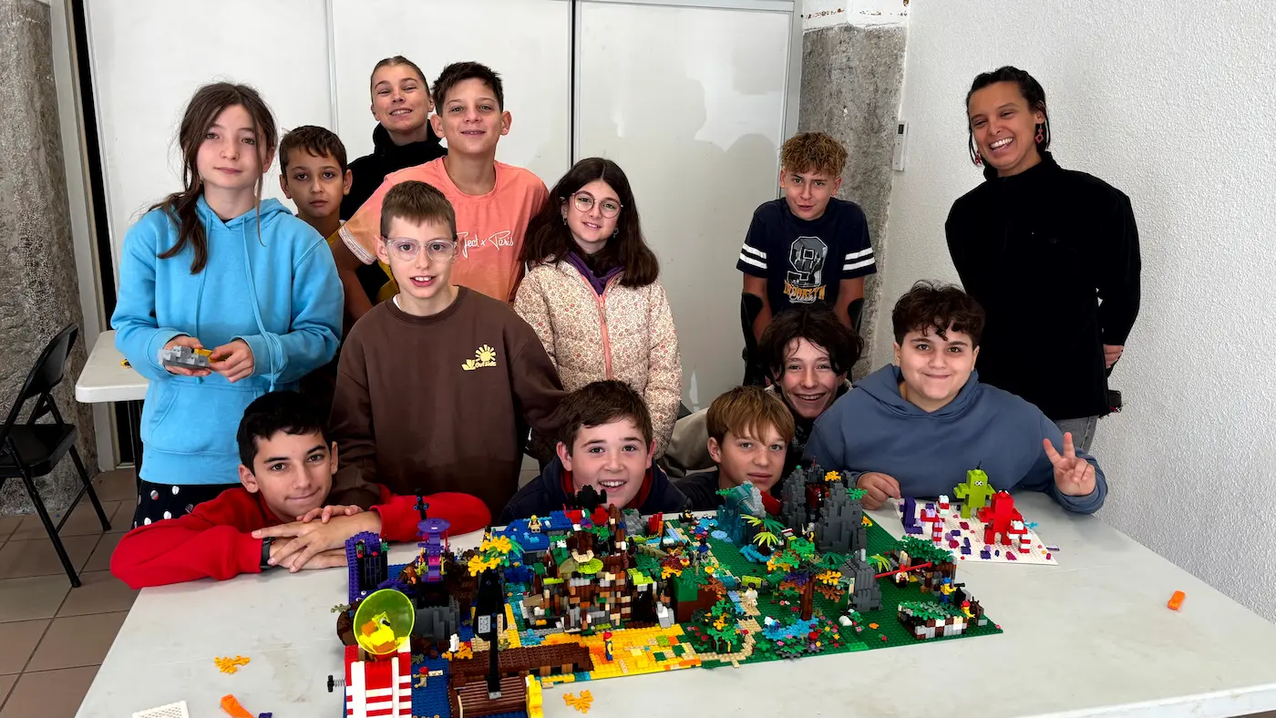 Hub collectivités 7 20/10/2026 Animation de centre de loisirs à Chomérac : un groupe d'adolescents pose derrière sa création en briques LEGO® après un défi par équipes