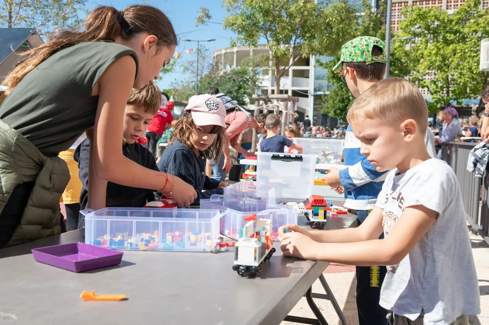 Stand d'animation LEGO® en extérieur lors d'un événement public : de nombreux visiteurs construisent avec des briques LEGO® autour du stand de Ludi Briques