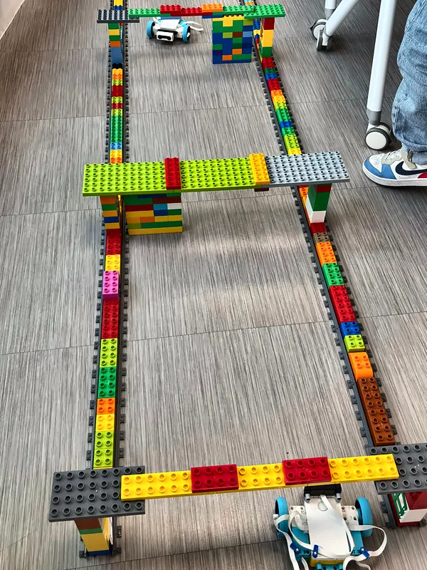 Circuit en briques DUPLO® avec arches et murs, que deux robots programmés parcourent en autonomie, au club robotique de Salon-de-Provence