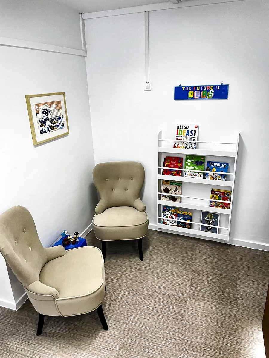 Coin détente avec deux fauteuils et un petit rayon de livres au magasin de jouets de Salon-de-Provence