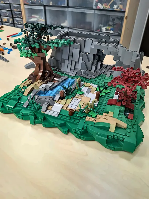 Accès libre 6 20/10/2026 Diorama de nature en briques LEGO® avec rochers gris, rivière bleue, grand arbre et feuillage rouge, construit en accès libre