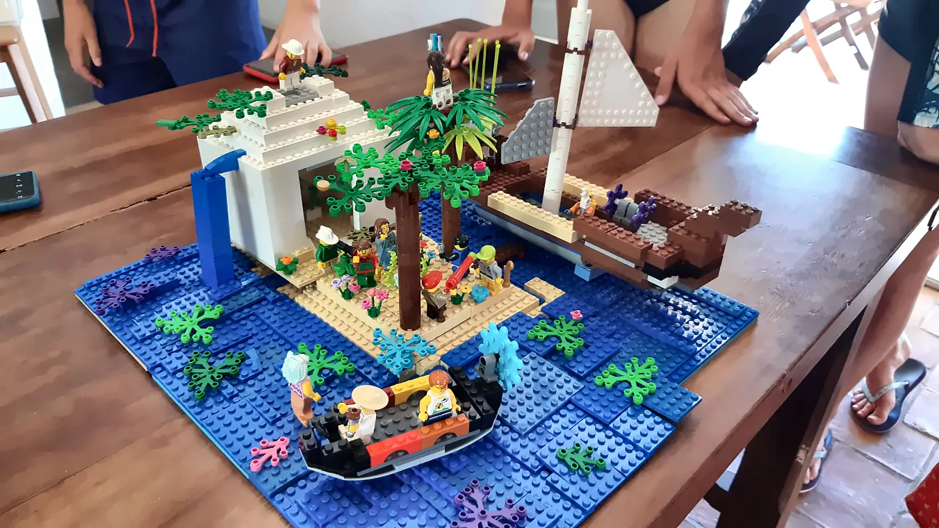 Activités enfants à Salon-de-Provence : île pirate en briques LEGO® avec palmiers, cascade et voilier, construite pendant un anniversaire