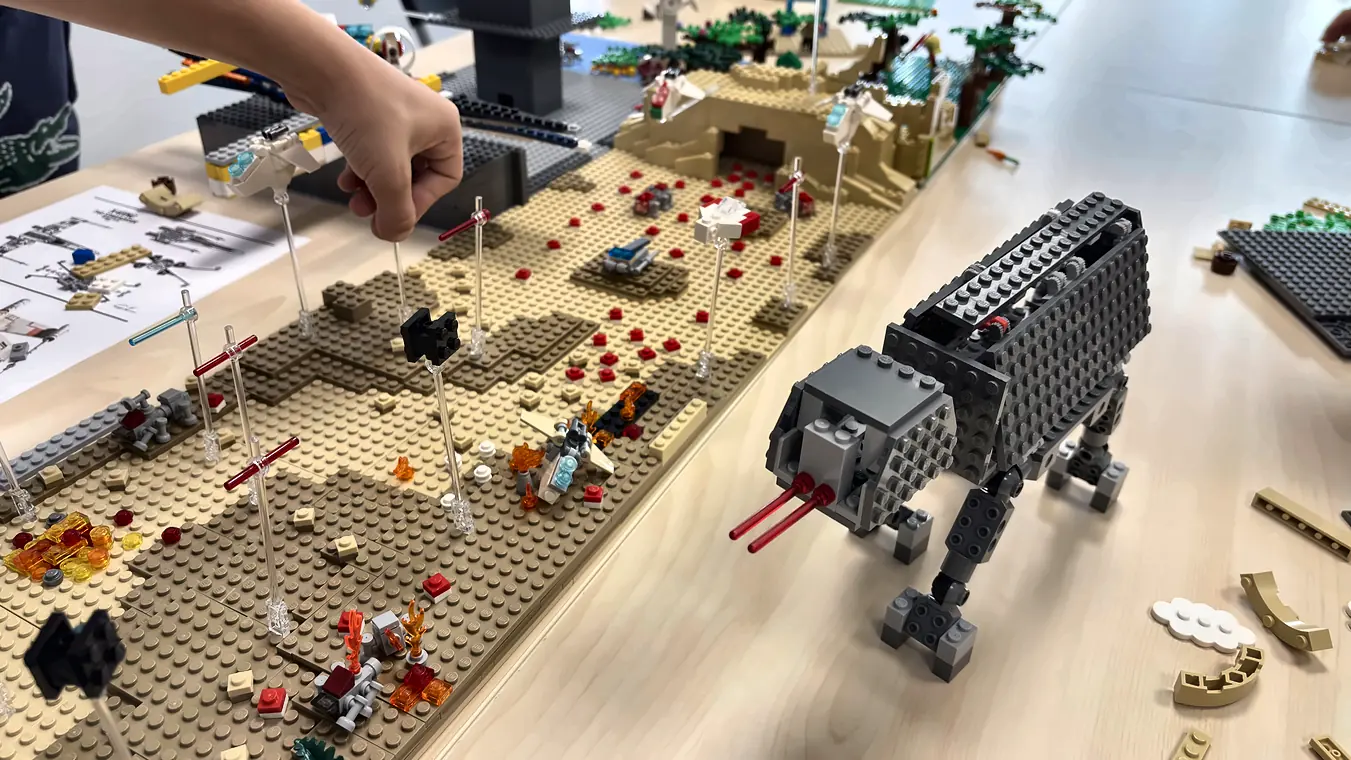 Grand marcheur gris à quatre pattes en briques LEGO® dans un décor de désert, construit pendant un anniversaire dans l'espace créatif