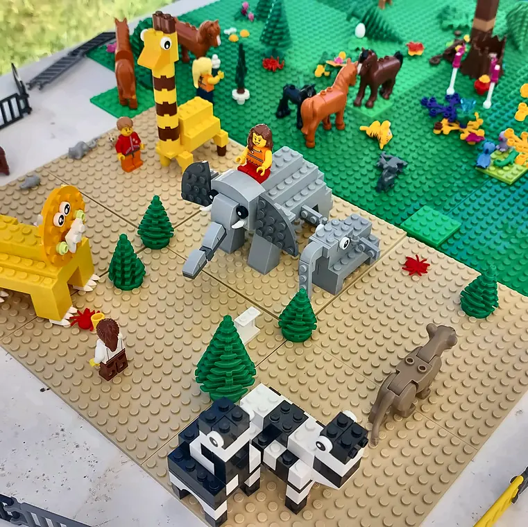 Activités enfants à Salon-de-Provence : savane en briques LEGO® avec girafe, éléphants et lions, créée pendant un anniversaire