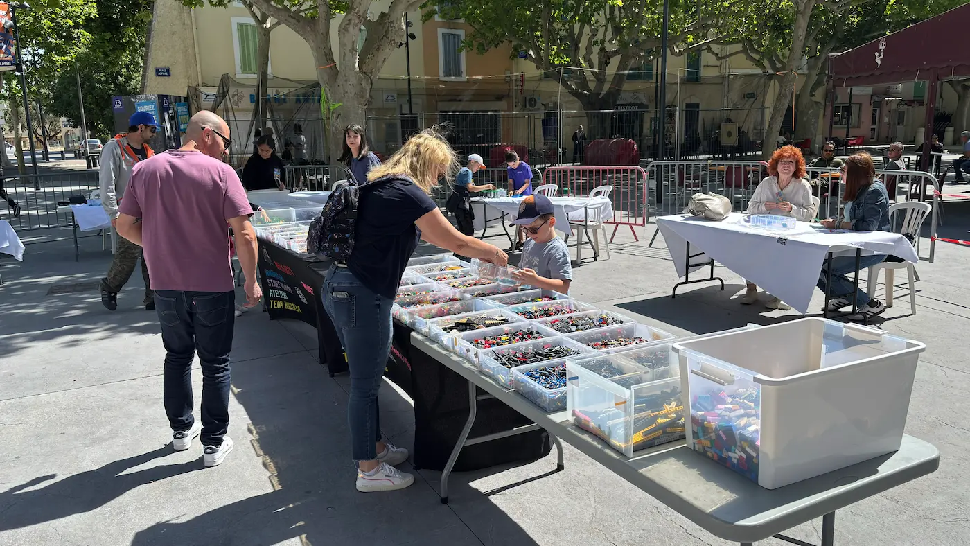 Sous-Hub Événement entreprise 8 20/10/2026 Stand d'animation en briques LEGO® avec de grands bacs de pièces triées, installé sur une place pour un événement entreprise grand public